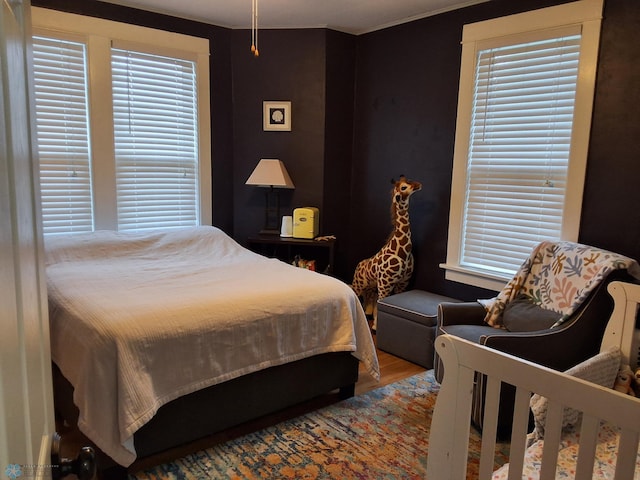bedroom with wood finished floors and multiple windows