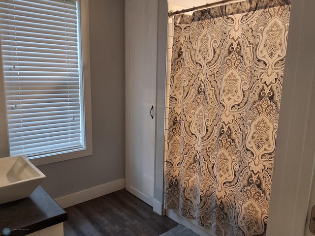 full bath with wood finished floors, baseboards, and a shower with shower curtain