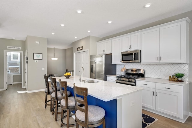 819 Roselyn Dr, Victoria, MN 55386 - kitchen with appliances with stainless steel finishes, a sink, a kitchen island with sink, tasteful backsplash, and white cabinetry