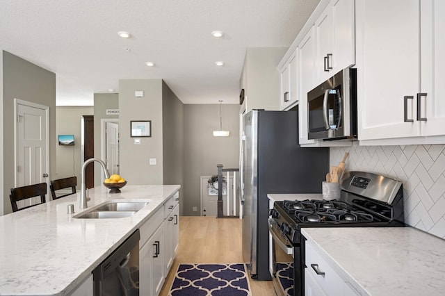 819 Roselyn Dr, Victoria, MN 55386 - kitchen featuring stainless steel appliances, a sink, light wood-style floors, white cabinetry, and tasteful backsplash