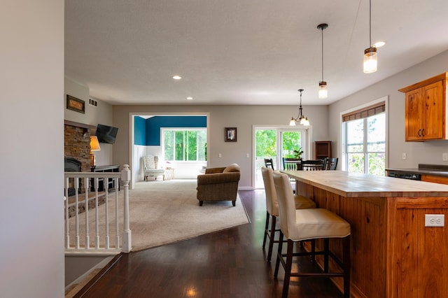 721 Quail Pkwy, Watertown, MN 55388 - kitchen featuring wood counters, dark wood finished floors, open floor plan, recessed lighting, and decorative light fixtures