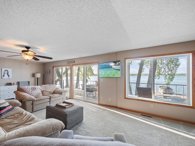 28604 Shore Dr, Starbuck, MN 56381 - carpeted living area featuring baseboards, a textured ceiling, and a ceiling fan