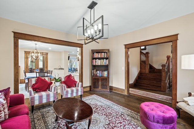 living room featuring a chandelier, wood finished floors, stairway, and baseboards
