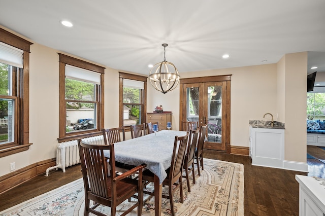dining room featuring a chandelier, dark wood-type flooring, recessed lighting, baseboards, and radiator