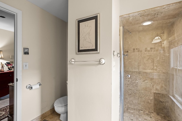 bathroom with a shower stall and toilet