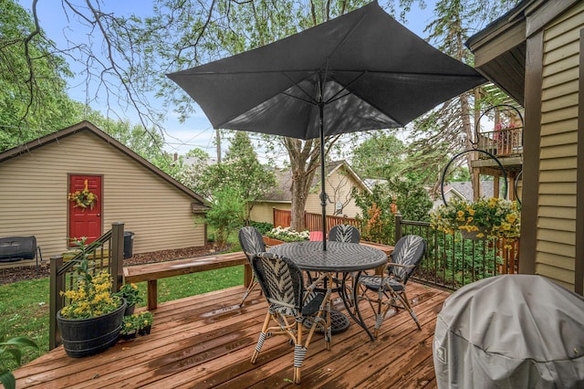 wooden deck with outdoor dining area and area for grilling