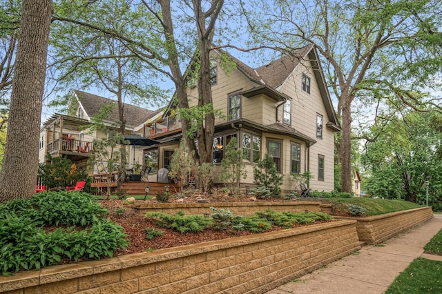 view of front of property featuring a balcony and a shingled roof