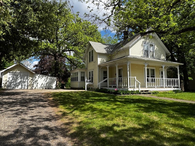208 Cush St, Jackson, MN 56143 - view of front of house featuring covered porch, an outdoor structure, a detached garage, driveway, and a front lawn