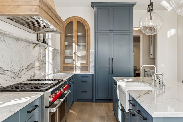1301 Mount Curve Ave, Minneapolis, MN 55403 - kitchen featuring double oven range, custom exhaust hood, tasteful backsplash, light wood-type flooring, and light stone counters