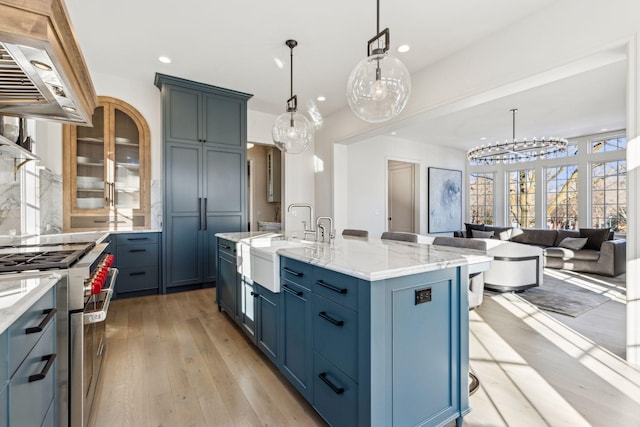 1301 Mount Curve Ave, Minneapolis, MN 55403 - kitchen with stainless steel stove, a sink, range hood, recessed lighting, and light stone countertops