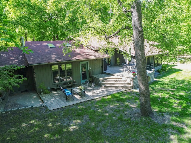 2536 Sandhill Ln NE, Carlos Twp, MN 56308 - rear view of house with a shingled roof, a sunroom, a deck, and a lawn