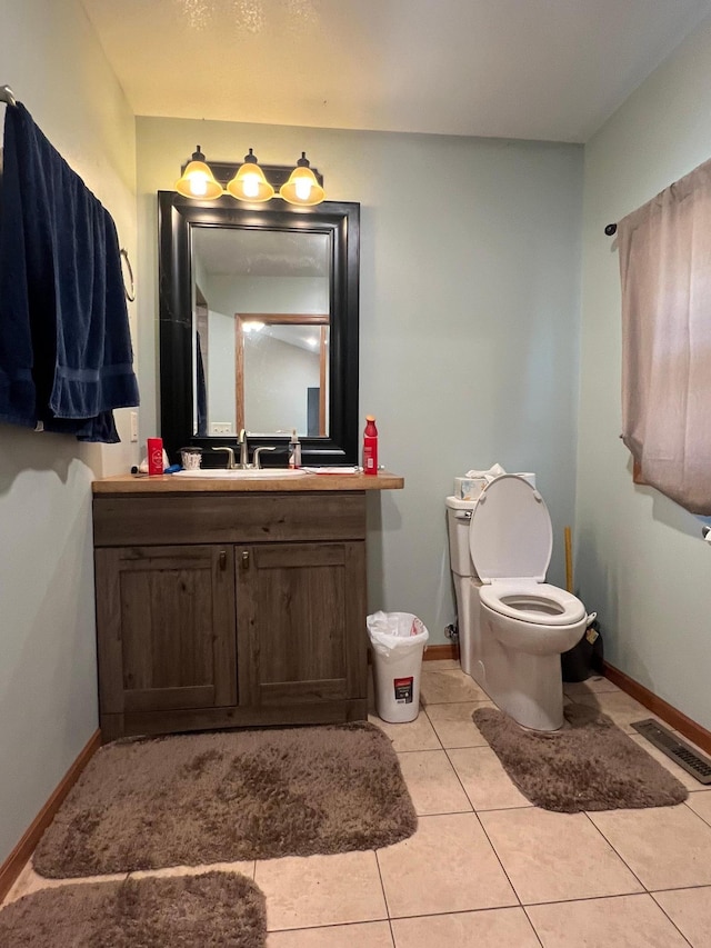 34373 State Highway 7, Foster Twp, MN 56225 - half bathroom featuring baseboards, tile patterned flooring, vanity, and toilet