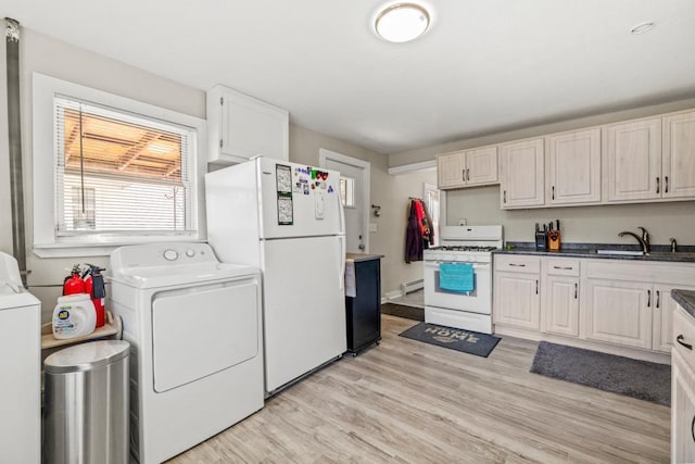 4959 5th St NE, Columbia Heights, MN 55421 - kitchen with white appliances, a sink, washing machine and dryer, light wood finished floors, and a baseboard radiator