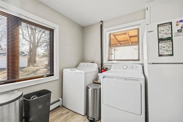4959 5th St NE, Columbia Heights, MN 55421 - clothes washing area with a baseboard radiator, washing machine and clothes dryer, and light wood-type flooring