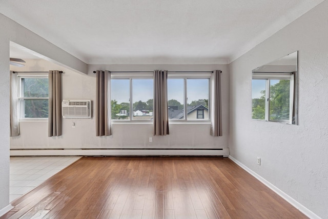 1540 Ashland Ave Unit 3, Saint Paul, MN 55104 - empty room featuring healthy amount of natural light, wood-type flooring, a textured wall, baseboards, and a wall mounted AC