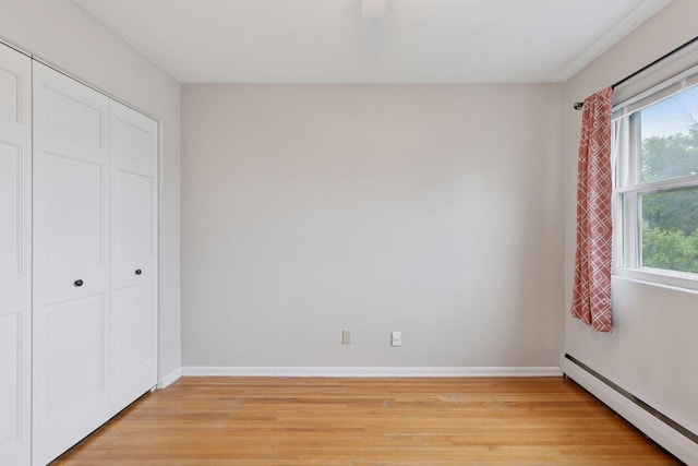 1540 Ashland Ave Unit 3, Saint Paul, MN 55104 - unfurnished bedroom with a baseboard heating unit, light wood-style floors, baseboards, a closet, and ceiling fan
