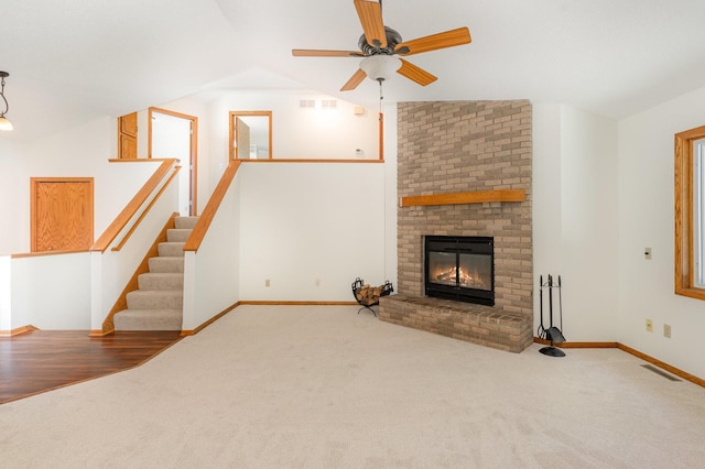 12761 Ethelton Way, Apple Valley, MN 55124 - unfurnished living room featuring carpet, ceiling fan, lofted ceiling, a brick fireplace, and baseboards