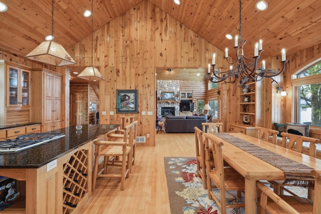 41849 Birchwood Dr, Emily, MN 56447 - dining room with high vaulted ceiling, wooden walls, wooden ceiling, a chandelier, and a stone fireplace