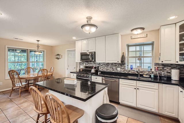 18046 Zodiac St NE, Columbus, MN 55025 - kitchen featuring stainless steel appliances, a sink, decorative backsplash, white cabinets, and a textured ceiling