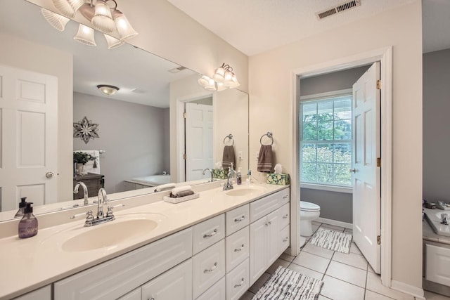 18046 Zodiac St NE, Columbus, MN 55025 - full bathroom with double vanity, toilet, tile patterned floors, a bath, and baseboards