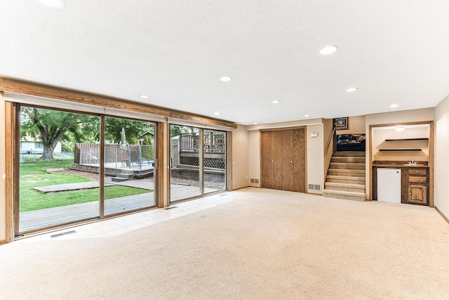 14308 Park Ave, Burnsville, MN 55337 - unfurnished living room with stairway, recessed lighting, carpet, baseboards, and a textured ceiling