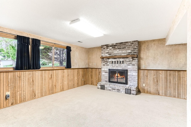 14308 Park Ave, Burnsville, MN 55337 - unfurnished living room featuring wooden walls, a fireplace, carpet flooring, a textured ceiling, and a wainscoted wall