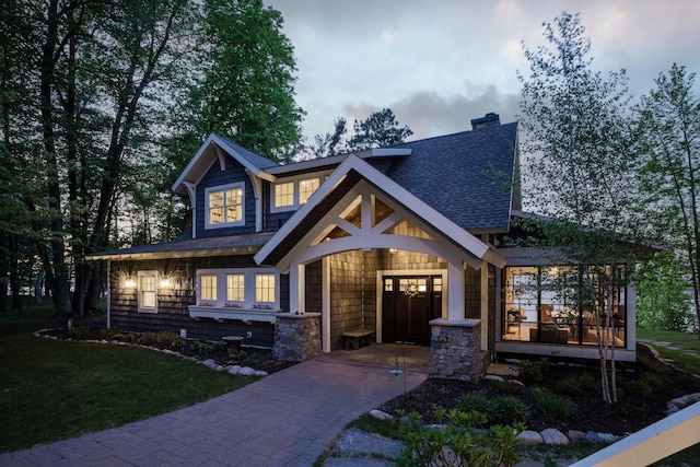 6024 Ojibwa Rd, Brainerd, MN 56401 - craftsman-style home with a shingled roof, a chimney, a front lawn, and driveway