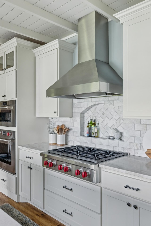 6024 Ojibwa Rd, Brainerd, MN 56401 - kitchen featuring wall chimney exhaust hood, stainless steel appliances, white cabinets, tasteful backsplash, and wood ceiling with exposed beams