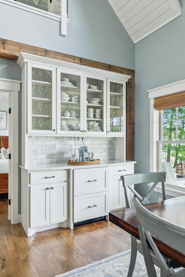 6024 Ojibwa Rd, Brainerd, MN 56401 - bar area with vaulted ceiling, decorative backsplash, and light wood-style flooring