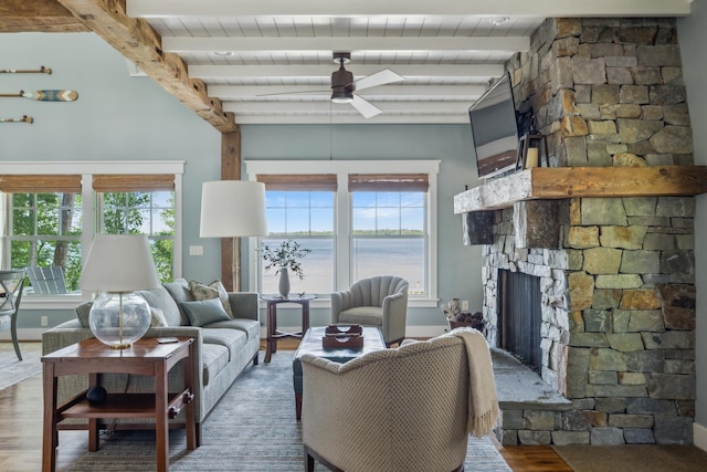 6024 Ojibwa Rd, Brainerd, MN 56401 - living area with a stone fireplace, wood finished floors, ceiling fan, wood ceiling with exposed beams, and baseboards