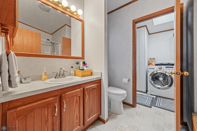 45642 Devils Lake Rd, Edna Twp, MN 56573 - bathroom with washer / dryer, tile patterned floors, ornamental molding, vanity, and toilet