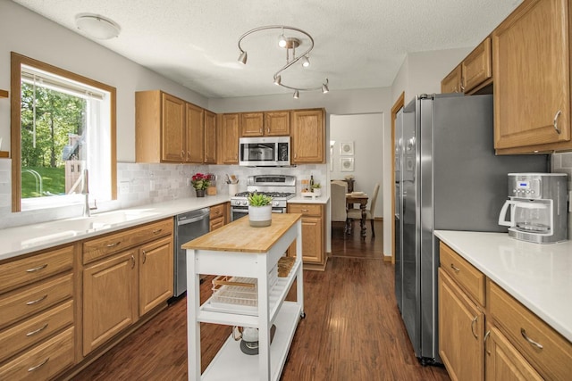 4132 Oakbrooke Curv, Eagan, MN 55122 - kitchen with appliances with stainless steel finishes, butcher block countertops, decorative backsplash, dark wood finished floors, and a textured ceiling