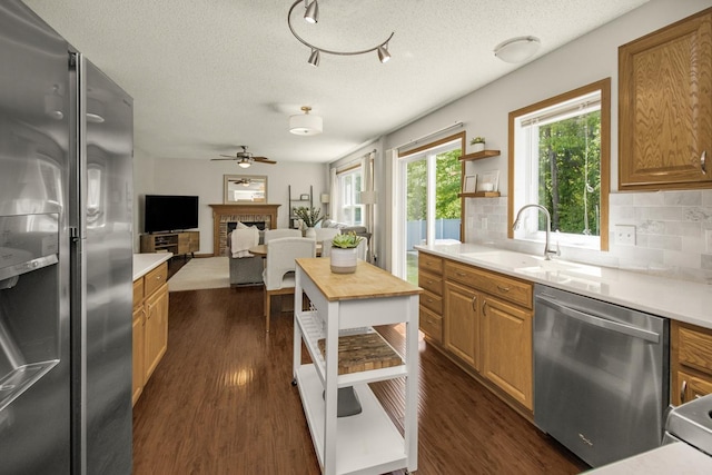 4132 Oakbrooke Curv, Eagan, MN 55122 - kitchen featuring stainless steel appliances, a sink, tasteful backsplash, light countertops, and dark wood-style floors