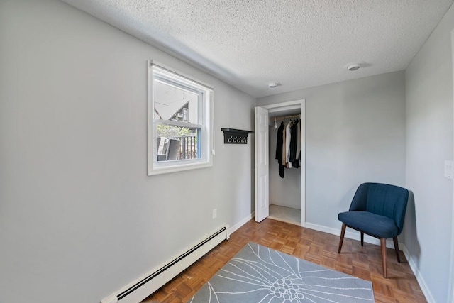 1460 36th St, Minneapolis, MN 55408 - sitting room featuring a baseboard heating unit, a textured ceiling, and baseboards