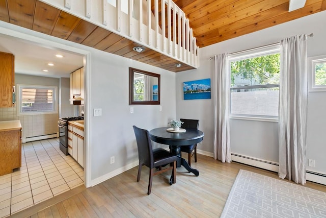1460 36th St, Minneapolis, MN 55408 - dining room with baseboard heating, healthy amount of natural light, light wood-style flooring, vaulted ceiling, and a baseboard heating unit