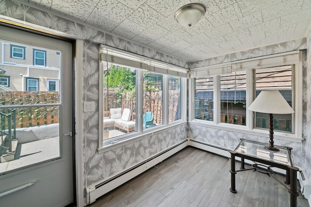 1460 36th St, Minneapolis, MN 55408 - unfurnished sunroom with wood finished floors, wallpapered walls, healthy amount of natural light, a baseboard heating unit, and baseboards