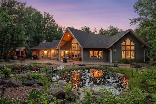 40335 Government Rd, Barry Twp, MN 55037 - back of house with a garden pond, a patio area, a fire pit, a chimney, and a shingled roof