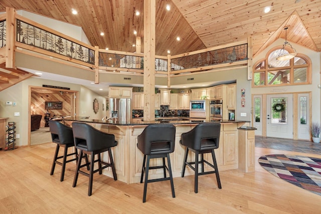 40335 Government Rd, Barry Twp, MN 55037 - kitchen featuring high vaulted ceiling, appliances with stainless steel finishes, light wood finished floors, wood ceiling, and cream cabinetry