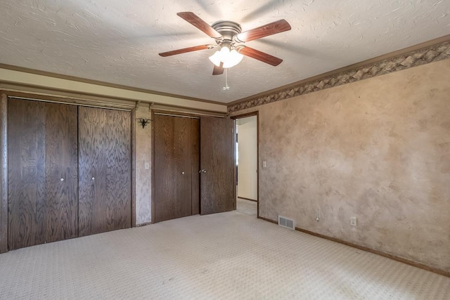 11197 608th Ave, Danville Twp, MN 56068 - unfurnished bedroom featuring carpet flooring, two closets, baseboards, ceiling fan, and a textured ceiling
