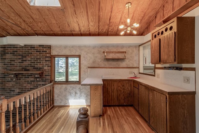 11197 608th Ave, Danville Twp, MN 56068 - kitchen with light wood-style flooring, a chandelier, wooden ceiling, wallpapered walls, and brown cabinetry