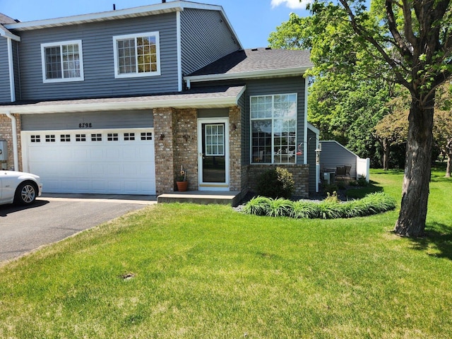8798 Hastings Cir NE, Blaine, MN 55449 - view of front of property with driveway, a front yard, an attached garage, and brick siding