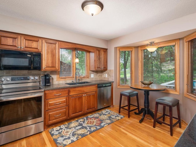 5705 Quinwood Ln N, Plymouth, MN 55442 - kitchen with appliances with stainless steel finishes, a sink, brown cabinets, and backsplash
