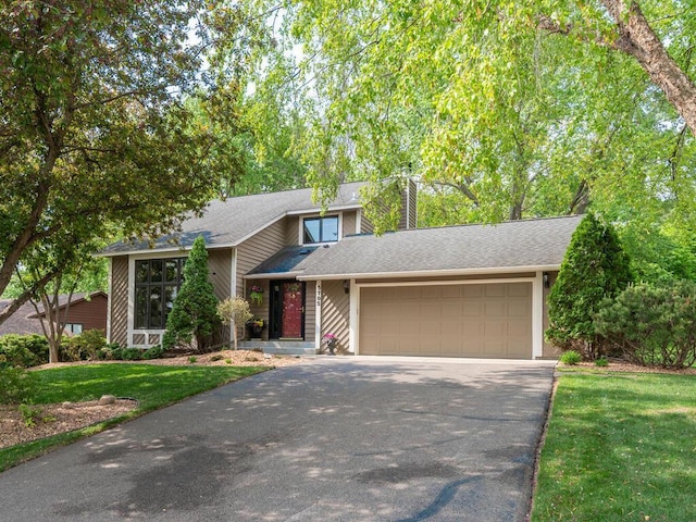 5705 Quinwood Ln N, Plymouth, MN 55442 - mid-century home with asphalt driveway, an attached garage, a chimney, a front yard, and a shingled roof
