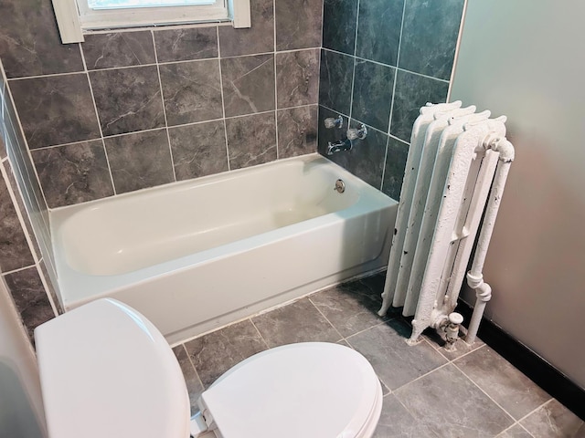 138 George St W, Saint Paul, MN 55107 - bathroom featuring radiator heating unit, toilet, and a tub to relax in