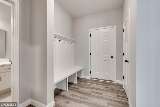 mudroom featuring light wood-style floors and baseboards