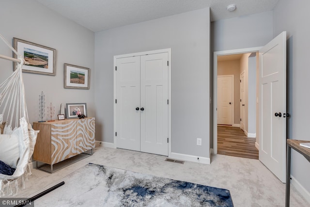 carpeted bedroom featuring baseboards and a closet
