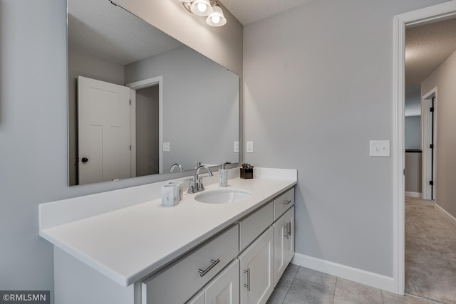 bathroom with baseboards, a textured ceiling, vanity, and tile patterned floors