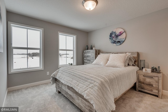bedroom featuring light carpet and baseboards