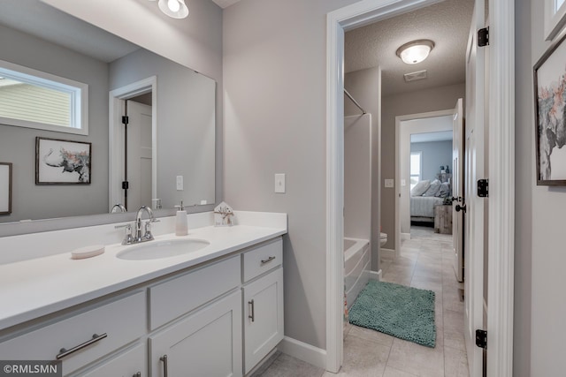 bathroom featuring vanity, tile patterned floors, plenty of natural light, and baseboards