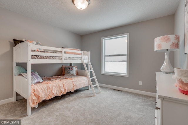 bedroom featuring carpet, baseboards, and a textured ceiling
